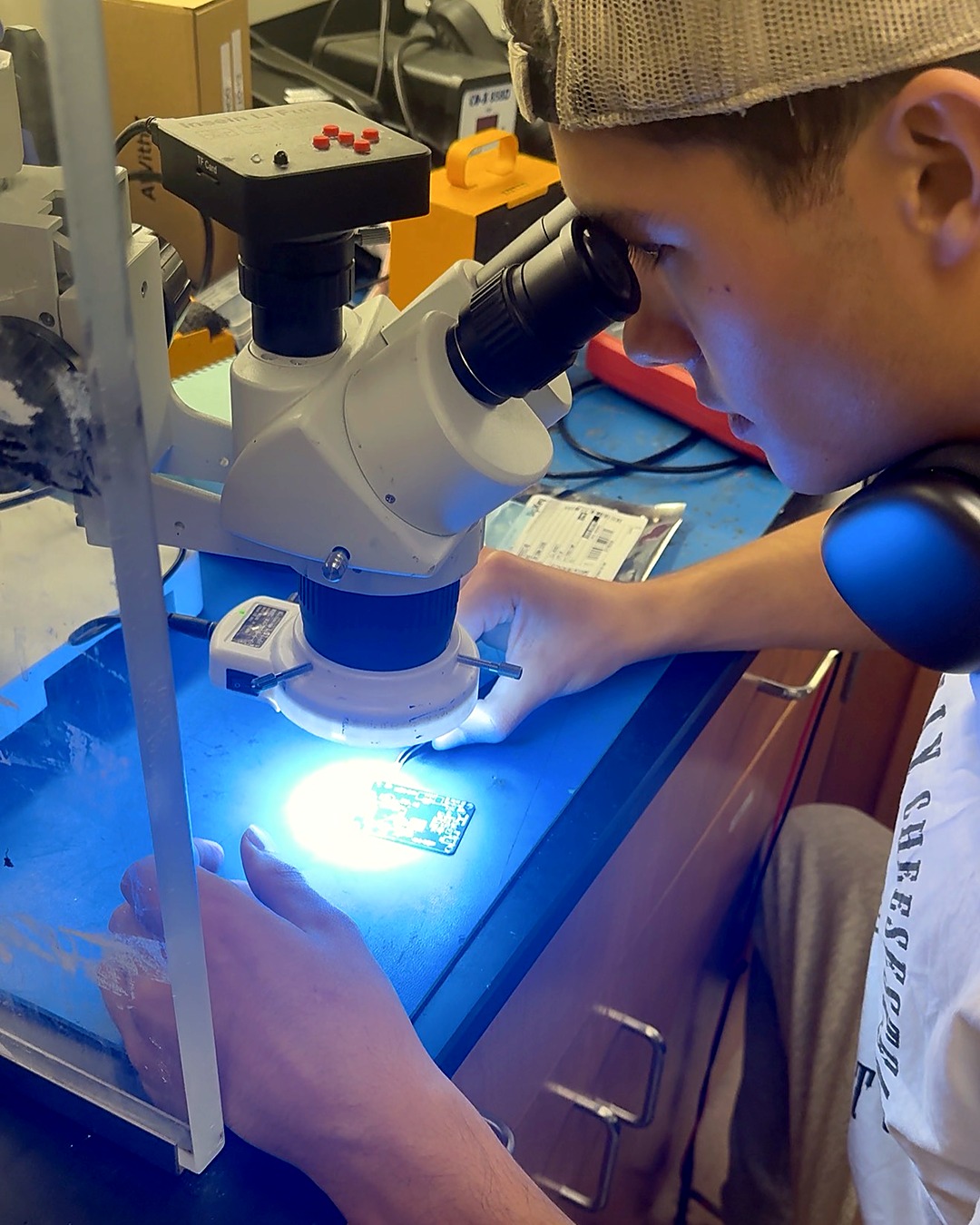 Christopher Sparrow looking at a circuit board under a microscope